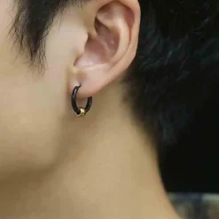 Sort ørering i stål med gylden kugle.